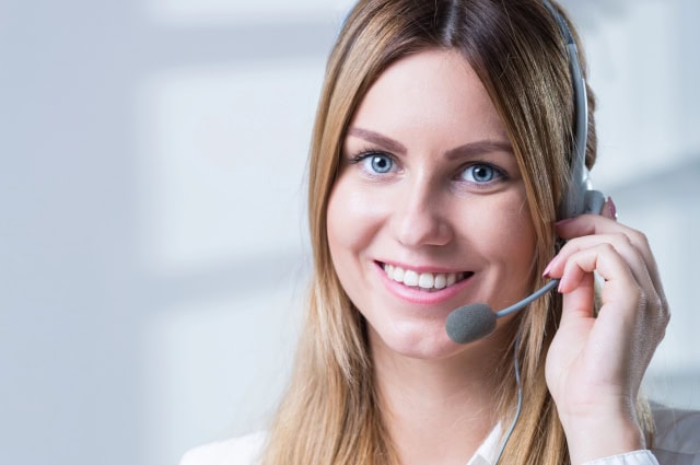 Smiling receptionist taking a call on headset