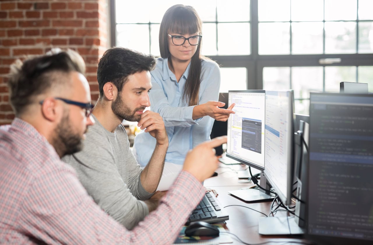 development team reviewing work on computer screens